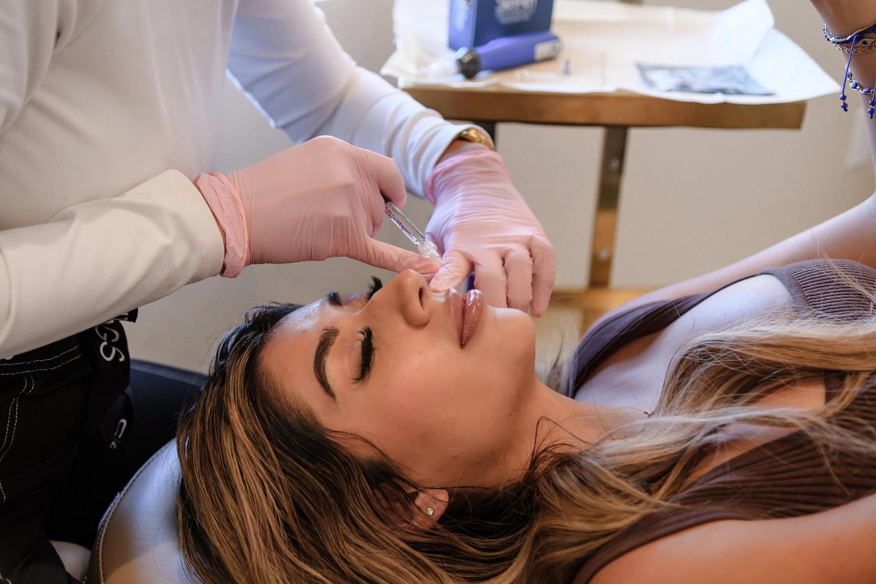 Medical provider administering a dermal filler injection in a clinical spa setting.